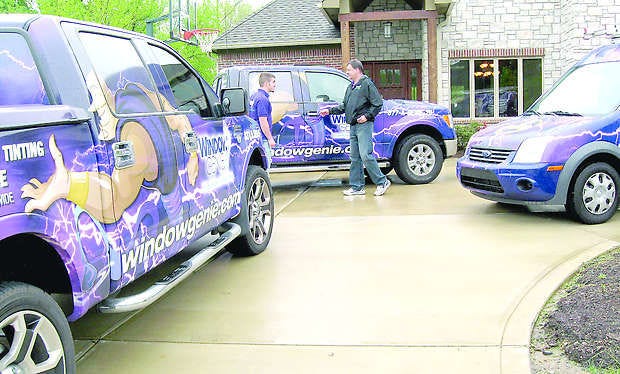 Mike Angle (right), newest Window Genie business owner near Mooresville, talks to one of his employees, Eric Bemish, before they go out on a job. Their purple vans with the big genie on each one are hard to miss. Mike and his wife, Karen own the franchise and live in Guilford Township. Photo by Amy Hillenburg.