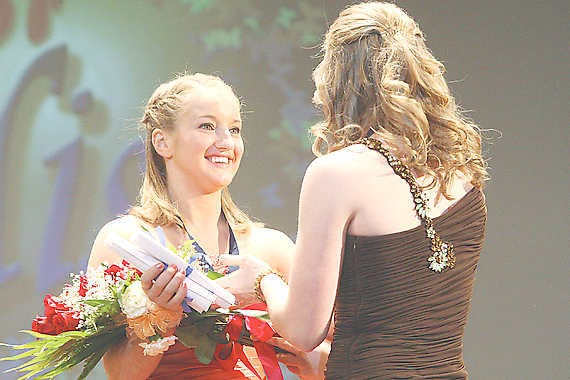 BEDFORD — Jordyn McCord, a Mitchell High School senior, accepts the winner’s bouquet from 2010 Junior Miss Abby Thorne. McCord won the 2011 title at the Bedford North Lawrence Performing Arts Center Saturday evening. (Times-Mail photos / GARET COBB)