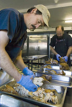 Mike Lindeau, a volunteer at Community Kitchen, and assistant director Tim Clougher strip turkeys Nov. 26 in preparation for 2008’s Thanksgiving feast. The kitchen served a record number of meals in 2008.David Snodgress | Herald-Times