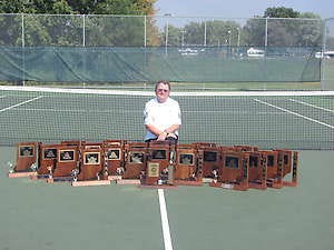 LOOGOOTEE — Former Loogootee tennis coach Rick Graves poses with the trophies he and the Lions have collected during his tenure. (Courtesy Photo).