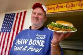 Gnaw Bone Food &amp; Fuel owner Beni Clevenger holds one of his world-famous tenderloins in this 2003 file photo. The famous tenderloin shop closed Friday to move from its Gnaw Bone home to the Salt Creek Golf Course clubhouse Jan. 15. Jeremy Hogan | Herald-Times