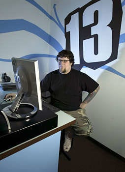 Jake Farris works at his computer June 30 to update the Studio 13 tattoo parlor\'s online advertising through Myspace.com. Studio 13 in Fort Wayne is one of a growing number of businesses using the Web site\'s free space for advertising and business promotion. Chad Ryan | Associated Press