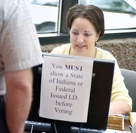 Jenn Marcum checks the identification of an absentee voter in the May 2006 primary, the first statewide election in which voters were required to show a state or federal ID.Chris Howell | Herald-Times