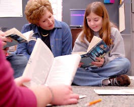 Teacher Jill Spenner follows along as sixth-grader Jennifer Ricke reads with her group at Riverview Middle School in Huntington. The school is experimenting with single-gender language arts classes, and both teachers and students say they like the result. Joel Philippsen | Associated Press