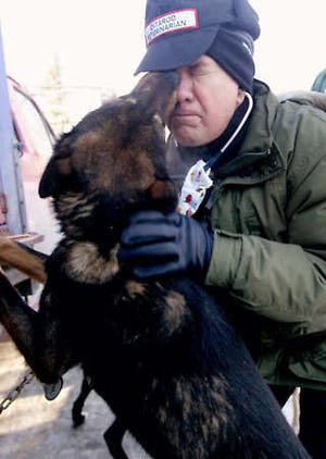Volunteer veterinarian Vern Otte, of Leawood, Kan., gets an unexpected lick in the eye Wednesday while checking one of Bob Bundtzen\'s sled dogs during the Iditarod Trail Sled Dog Race vet check in Wasilla, Alaska. All dogs running in the 1,049 mile sled dog race, which started Saturday, undergoes a complete physical checkup to make sure they are fit to run the Anchorage-to-Nome race. Al Grillo | Associated Press