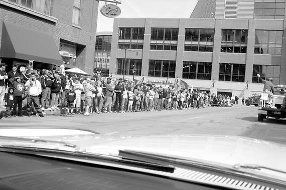 Fans at the end of Saturday’s Hoosier Hysteria Parade in Indianapolis wave as Steve Page takes a photo from the car in which Elmer and Viola Reynolds of Martinsville were riding.