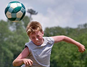 BEDFORD — Levi Meadows heads the ball during soccer drills at the British Soccer Camp Thursday at Otis Park. (Times-Mail / PETE SCHREINER).