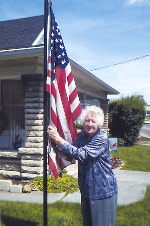 Special to the Times-Mail / CLAUDE PARSONSBEDFORD — Icel Naugle prepares to raise the American flag in her front yard. Flag Day on Saturday was also her 94th birthday. The retired school teacher has raised and lowered the flag each day for 43 years.