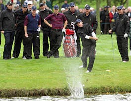 U.S. Ryder Cup team players and caddies watch as Jim Furyk attempts to skip his ball over the lake on No. 7 during Wednesday\'s practice round at the K Club in Straffan, Ireland. The Ryder Cup begins on Friday. Peter Morrison | Associated Press