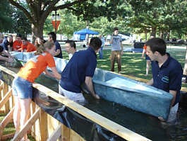 Members of the Polytechnic University team from Brooklyn, N.Y., lower their concrete canoe into the testing tank at Oklahoma State University during the national concrete canoe competition Thursday in Stillwater, Okla. Twenty-three teams are competing this week. Shaun Schafer | Associated Press