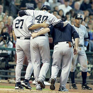 New York Yankees pitcher Chien-Ming Wang (40) is helped off the field after injuring his foot while scoring from second Sunday in Houston.Pat Sullivan | Associated Press