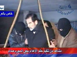 This video image released by Iraqi state television shows Saddam Hussein\'s guard wearing a ski mask and leading the deposed leader to the gallows Saturday moments before Saddam’s execution. IRAQI TV| HO | Associated Press