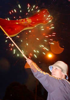 A boy waves a Montenegrin flag as fireworks illuminate the skies in Podgorica, Montenegro, after parliamentary deputies voted to proclaim independence for the tiny Balkan republic, forming a new European state and formally dissolving what was left of Yugoslavia. Risto Bozovic | Associated Press