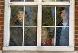 Students peer out at the broken window at the University of North Carolina out of which two students fell Friday. Sara D. Davis | Associated Press