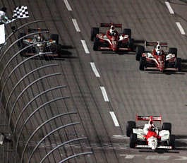 Helio Castroneves takes the checkered flag in front of, from left to right, Tomas Scheckter, Dan Wheldon and Scott Dixon to win the IRL Bombardier Learjet 500 at Texas Motor Speedway Saturday. LM Otero | Associated Press