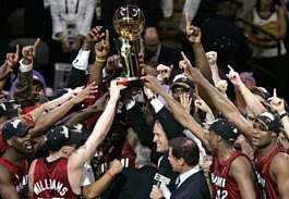 The Miami Heat reach for the Larry O\'Brien Trophy after winning the NBA Championship by beating the Dallas Mavericks in Game 6 of the NBA basketball finals in Dallas, Tuesday, June 20, 2006. Miami won, 95-92. (AP Photo/Donna McWilliam)