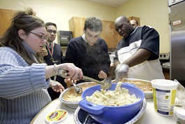 Psychologist Samantha Barton, left, gives a lesson on cooking to Josh Wolf, center, and Hameed Bradely Monday as part of a program for young adults challenged by autism, mental retardation and other disabilities to learn dating and social skills. Shiho Fukada| Associated Press