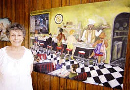 Sammye Dina Smith stands next to her painting "Sunrise Cafe." Monty Howell | Herald-Times