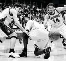 Northwestern\' Davor Duvancic (left) and Mohamed Hachad (14) chase after a loose ball as it slips behind Michigan\'s Brent Petway during the first half Saturday of Northwestern\'s 69-53 win. AP photo