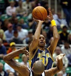 Indianas Reggie Miller shoots over Utahs Raja Bell during Tuesday nights game in Salt Lake City. The Pacers won 89-83. AP photo