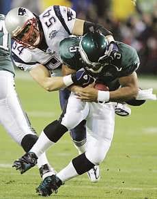New Englands\' Teddy Buschi sacks Philadelphia\'s Donovan McNabb early in the first quarter of Super Bowl XXXIX in Jacksonville, Fla., Sunday night. The Patriots won their third title in four years, 24-21. AP photo