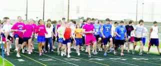 Members of the Martinsville boys\' and girls\' track and field teams pace the track surface to warm up before Wednesday\'s practice at the high school. The Artesians will kick off their season today in a three-way meet versus Edgewood and Brown County in Nashville. Photo by Greg Mitchell.