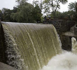 Water rushes over the spill-wall from the Byram River Thursday at the mill in the Glenville section of Greenwich, Conn. Between 4 and 12 inches of rain fell on Connecticut during the past week, with 3 or more inches predicted in coming days.Douglas Healey | Associated Press