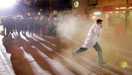 A reveler is pepper-sprayed by Madison police officers as they clear the crowd off State Street early Sunday, during the annual Halloween celebration. Michelle Stocker | Associated Press