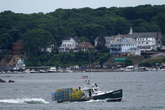 A lobster boat carries a heavy load of traps as it motors out to sea near Peaks Island from Portland, Maine, on July 8.
