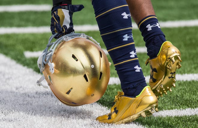 A player picks up a helmet during the Notre Dame spring football Blue-Gold game Saturday, April 22, 2017, at Notre Dame Stadium in South Bend. Tribune Photo/ROBERT FRANKLIN via FTP
