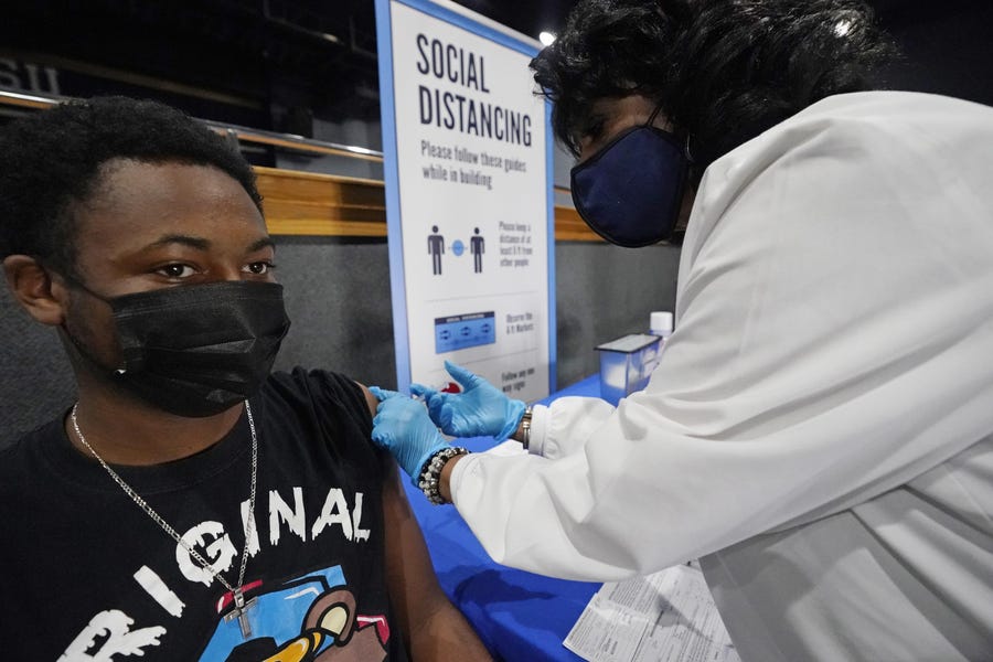 Jackson-Hinds Comprehensive Health Center nurse Maggie Bass gives Eric Wilson, 20, a dose of the Moderna COVID-19 vaccine at an open vaccination site sponsored by the university and the medical center in the Rose E. McCoy Auditorium at Jackson State University in Jackson, Miss., on Aug. 3. Wilson recently lost his father to COVID-19.