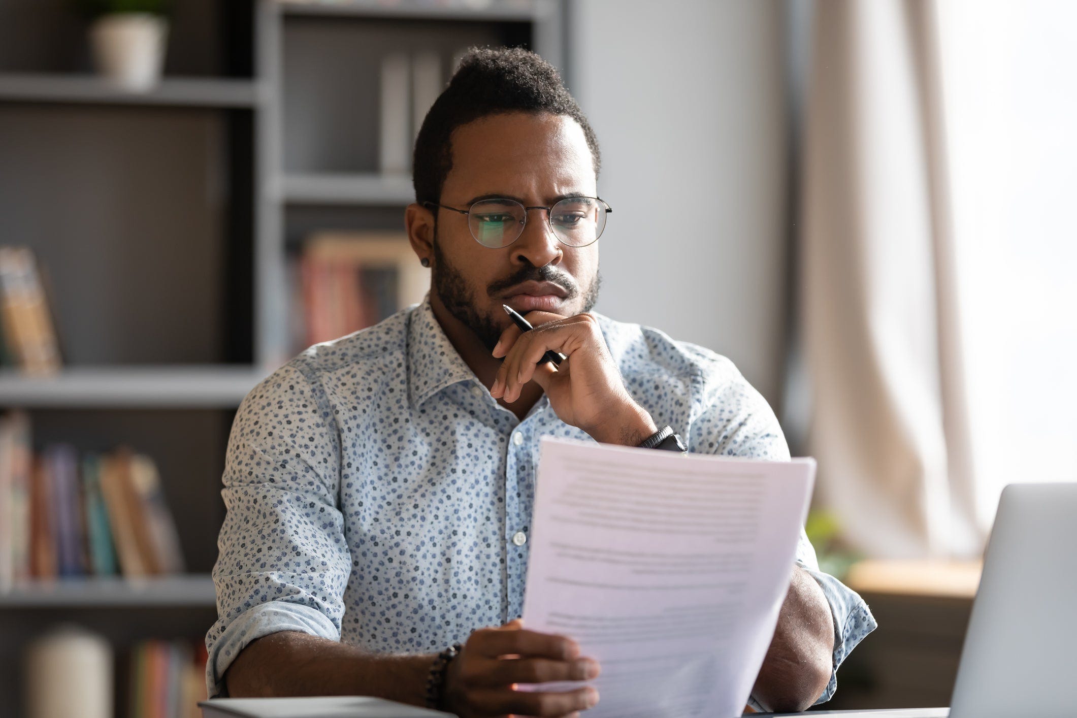 Small business owner reviewing paper documents while using TurboTax to prepare filings.