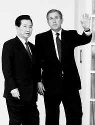 President Bush waves as he and South Korean President Kim Dae-jung leave the Oval Office Wednesday in Washington. Bush told Kim on Wednesday that the United States views North Korea as a threat and would not immediately resume negotiations with the communist regime. AP photo