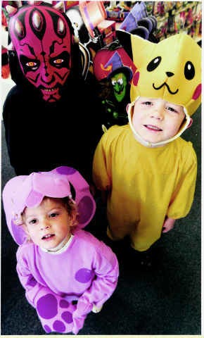Favorite halloween costumes for 1999 include "Darth Maul," left, from The Phantom Menace movie; "Magenta," center, a character in the "Blue\'s Clues" television show; and Pikachu, one of the 150 Pokemon characters. Modeling the costumes are, from left, Kory, Kirsten and Kevin McDaniel. Costumes courtesy Factory Card Outlet/Staff photo by David Snodgress