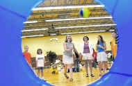 Daryl Fenio, who is graduating from medical school and plans to work as an anesthesiologist, plays a football-toss game during a school carnival at Unionville Elementary School Friday. On Fenio\'s right are her daughters, Jamie and Nicole. Staff photo by Jeremy Hogan