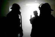 Bloomington City firefighters are stopped by Jeff Fuller, center, of the Indiana State Fire Marshall\'s office, in the smoky hallway of the empty Grandview. City firefighters were applying several hours of classroom instruction in this hands-on test of communication and organization in incident. Staff photo by Monty Howell