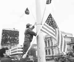 Bosnian workers put up the U.S. flag alongside the Bosnian flag in central Sarajevo Sunday, the day before U.S. President Clinton is due to arrive in the Bosnian capital for a one-day visit, during which he will be sharing a holiday meal with U.S. troops stationed in Tuzla. ap photo