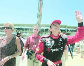 Former Indy 500 champion Arie Luyendyk waves to the crowd as he heads up Gasoline Alley with his wife, Mieke, following Luyendyk\'s qualifying run on Sunday at the Indianapolis Motor Speedway. Staff photo by Jeremy Hogan