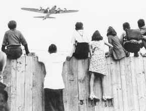 Children at Tempelhof airport watch U.S. airplanes bringing in supplies to circumvent the Soviet Union\'s blockade of West Berlin in this undated photo. The airlift began June 25, 1948, and continued for 11 months. AP file photo
