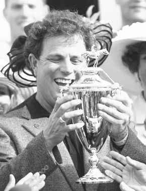 Real Quiet owner Michael Pegram admires the winner\'s trophy his horse won at the Kentucky Derby Saturday. AP photo