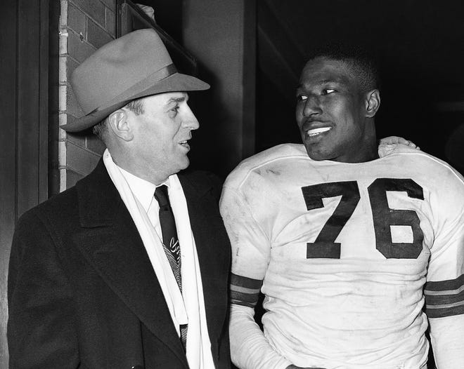 Browns fullback Marion Motley, right, stands with coach Paul Brown after a game against Buffalo in Cleveland, Dec. 19, 1948.