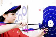 Lindsey Robertson practices at the Archers Spot indoor archery range in Bloomfield. These arrows, part of five shot from 20 yards, will be one set of several. Robertsons mother and father also shoot. Staff photo by Monty Howell