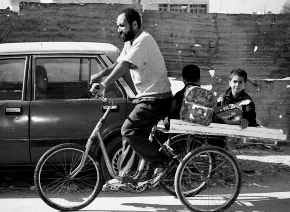 A man takes his two children to school on a three-wheeled bicycle in the Palestinian refugee camp of Ein el-Hilweh Saturday. It was business as usual Saturday in the camp in south Lebanon the day after a peace agreement was signed between Israeli and Palestinian leaders, but elsewhere in the Middle East, trouble was brewing as Israeli West Bank settlers vowed to stage protests. AP PHOTO