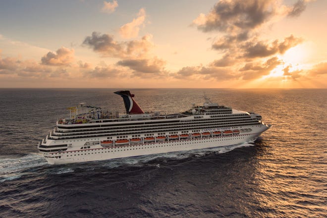 A Carnival cruise ship sailing in the ocean during the sunset.