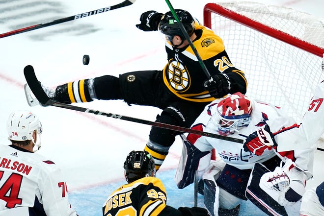 Boston Bruins Curtis Lazar (20) je kontrolován proti brankáři Washingtonu Capitals Vitekovi Vanesskovi, hned po střele během třetí třetiny přípravného hokejového zápasu NHL v Bostonu, ve středu 6. října 2021. (AP Photo/Charles Krupa)