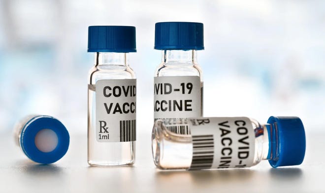 Four vials labeled COVID-19 vaccine.