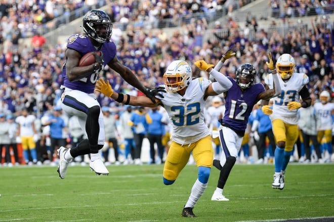 Baltimore Ravens running back Latavius Murray (28) scores a touchdown as Los Angeles Chargers defensive back Alohi Gilman (32) tries to stop him during the first half of an NFL football game, Sunday, Oct. 17, 2021, in Baltimore. (AP Photo/Nick Wass)