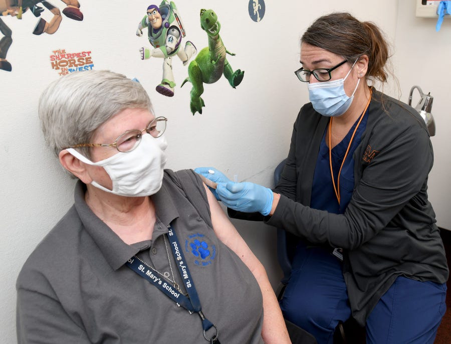 Sister Kathy Longheier with St. Mary's School receives a COVID-19 booster vaccine shot from registered nurse Christine Gogerty at a clinic at the Massillon Health Department in northeast Ohio on Oct. 12.