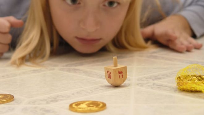 Credit: Getty Images / sandoclr Dreidel is a fun way to learn Hebrew characters.