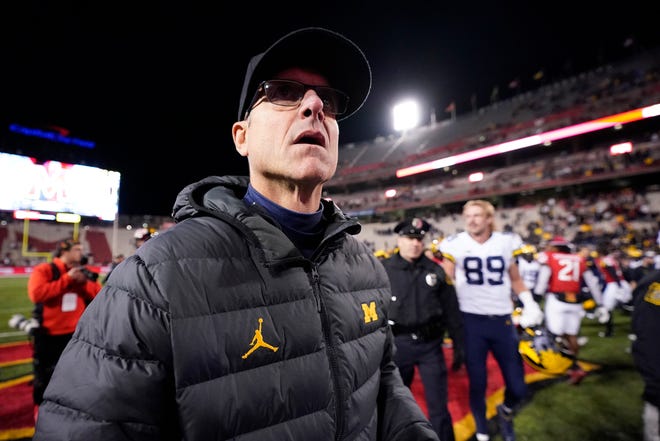 Michigan head coach Jim Harbaugh walks on the field after an NCAA college football game against Maryland, Saturday, Nov. 20, 2021, in College Park, Md. Michigan won 59-18. (AP Photo/Julio Cortez)